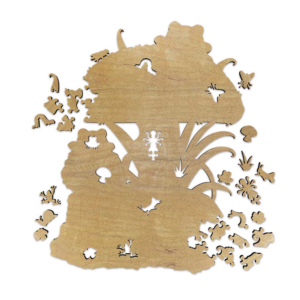 Unpainted cherry veneer wood puzzle showing the natural wood grain and laser-cut piece shapes, with whimsy pieces in the form of frogs, a snail, mushrooms, grass, and insects displayed around the edges.