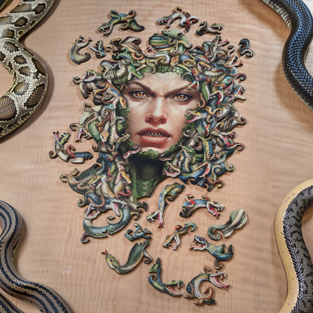 Fathom Puzzles Bad Hair Day Wooden Laser Cut Jigsaw 200 Pieces Geoff Cota Medusa surrounded by her hair of snakes Lifestyle shot on table with snakes