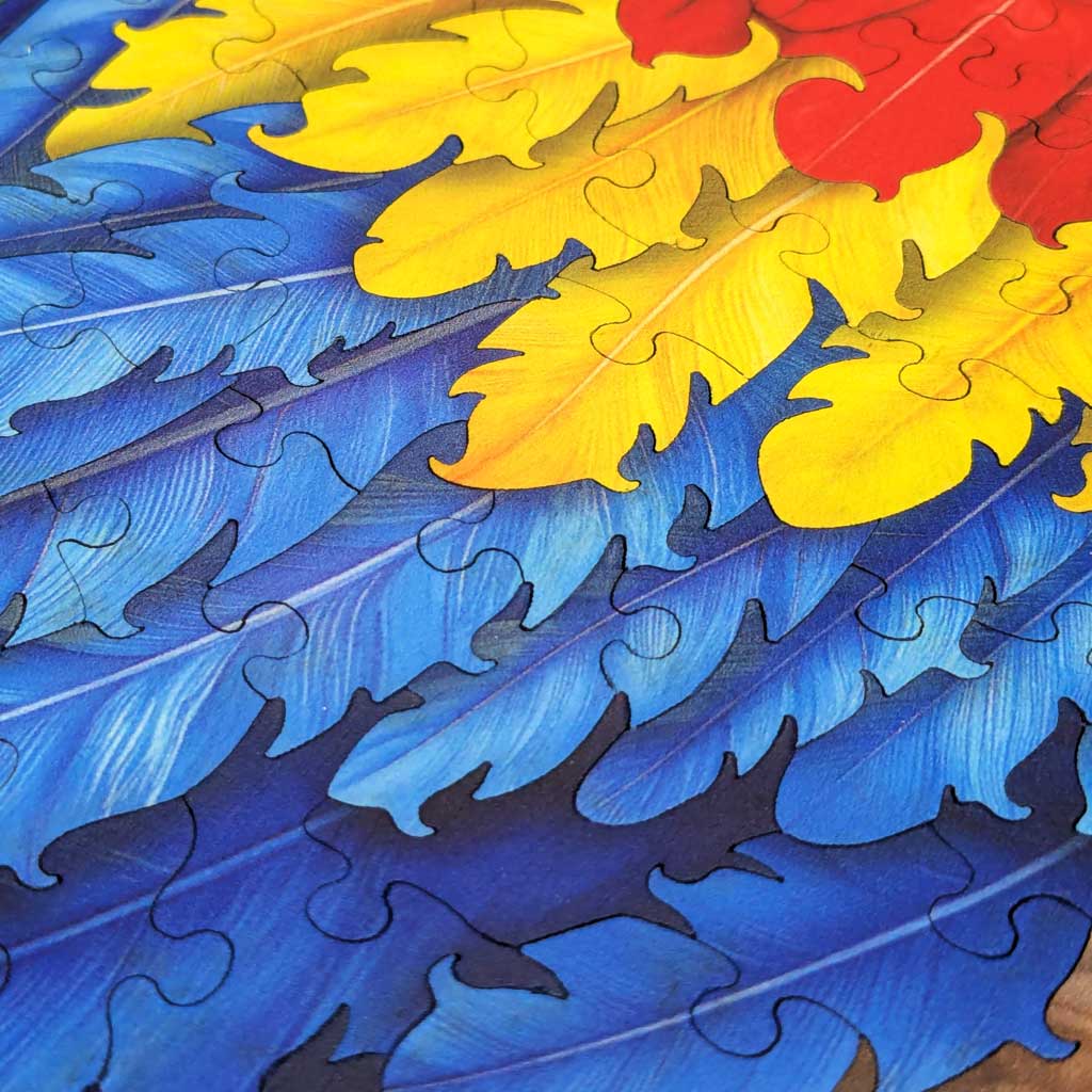 Loose yellow and blue feather-shaped wooden puzzle pieces on table