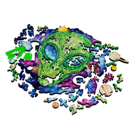 The Stargazer puzzle partially disassembled, showing all pieces spread out against a white background with the neon green acrylic tractor beam pieces visible at left.
