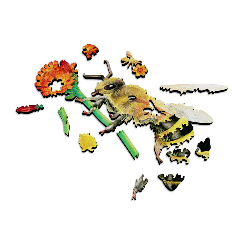 Partially assembled wooden bee puzzle with several colorful pieces spread out, revealing the laser-cut edges and unique piece shapes