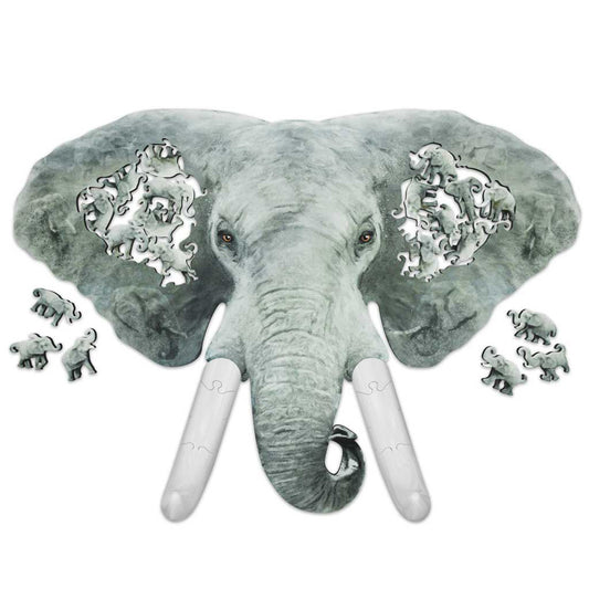 Overhead view of an elephant-shaped wooden jigsaw puzzle, with family-shaped elephant cutouts in each ear and loose elephant pieces around the edges.